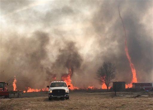 In this image made from a Feb. 18, 2016 video by Dean Cull, deputy chief of the Southern Platte Fire Protection District, a twisting fire, also known as a fire tornado, shoots up in the air as the grass fires spread on the field in Platte County, Mo. Firefighters in northwest Missouri are continuing to watch the site of a grass fire fueled by high winds that damaged up to 1,500 acres of land in Platte County. (Dean Cull/Southern Platte Fire Protection District via AP)
