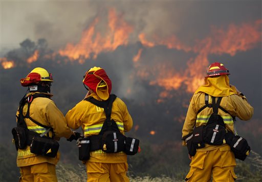 Upland firefighters, from left, Nima Homayounieh, Joseph Armendariz, and Capt. Joe Burna, watch as flames burn toward Highway 94 near Potrero, Calif., on Monday, June 20, 2016. (Hayne Palmour IV/San Diego Union-Tribune via AP)