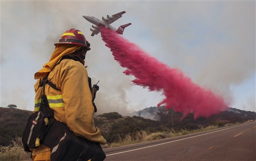 Upland Fire Capt. Joe Burna watches as a tanker drops fire retardant to stop a wildfire from jumping over Highway 94 near Potrero, Calif., on Monday, June 20, 2016. (Hayne Palmour IV/San Diego Union-Tribune via AP)