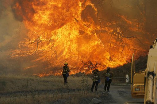 A hillside erupts in flame as a raging wildfire fire burns in Placerita Canyon in Santa Clarita, Calif., Monday, July 25, 2016. A raging wildfire that forced thousands from their homes on the edge of Los Angeles continued to burn out of control Monday as frustrated fire officials said residents reluctant to heed evacuation orders made conditions more dangerous and destructive for their neighbors. (AP Photo/Nick Ut)