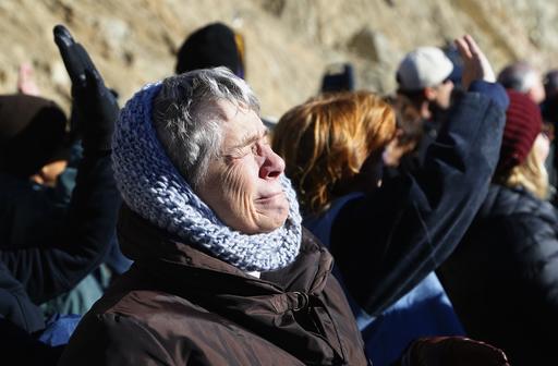 A family member is overcome as she watches a missing man formation of fire fighting planes as they fly over during a dedication ceremony for the new Granite Mountain Hotshots Memorial State Park as a tribute to the 19 firefighters killed during a 2013 wildfire Tuesday, Nov. 29, 2016, in Yarnell, Ariz. Gov. Doug Ducey said the 3-mile trail and memorial would serve as a lasting tribute to the fallen firefighters' heroism.(AP Photo/Ross D. Franklin)