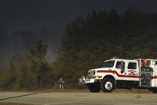 Volunteer firefighter's Sheri Torbett and Jeannie Vaughn, left, with the Sequoyah Volunteer Fire Department, use leaf blowers remove debris off the break near the Mowbray Volunteer Fire Hall in Soddy-Daisy, Tenn., on Thursday, Nov. 10, 2016. (Tim Barber /Chattanooga Times Free Press via AP)